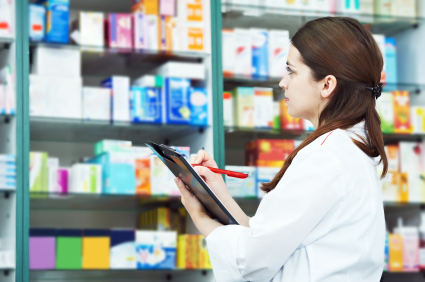 A female pharmacist takes inventory of pharmacy supplies
